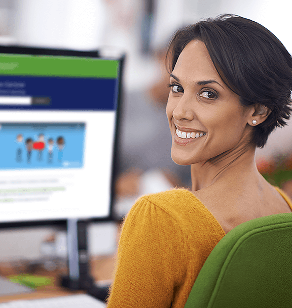 Woman looking over shoulder with Compliance Central web site on screen in the background.